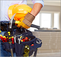 Builder handyman with construction tools. House renovation background.